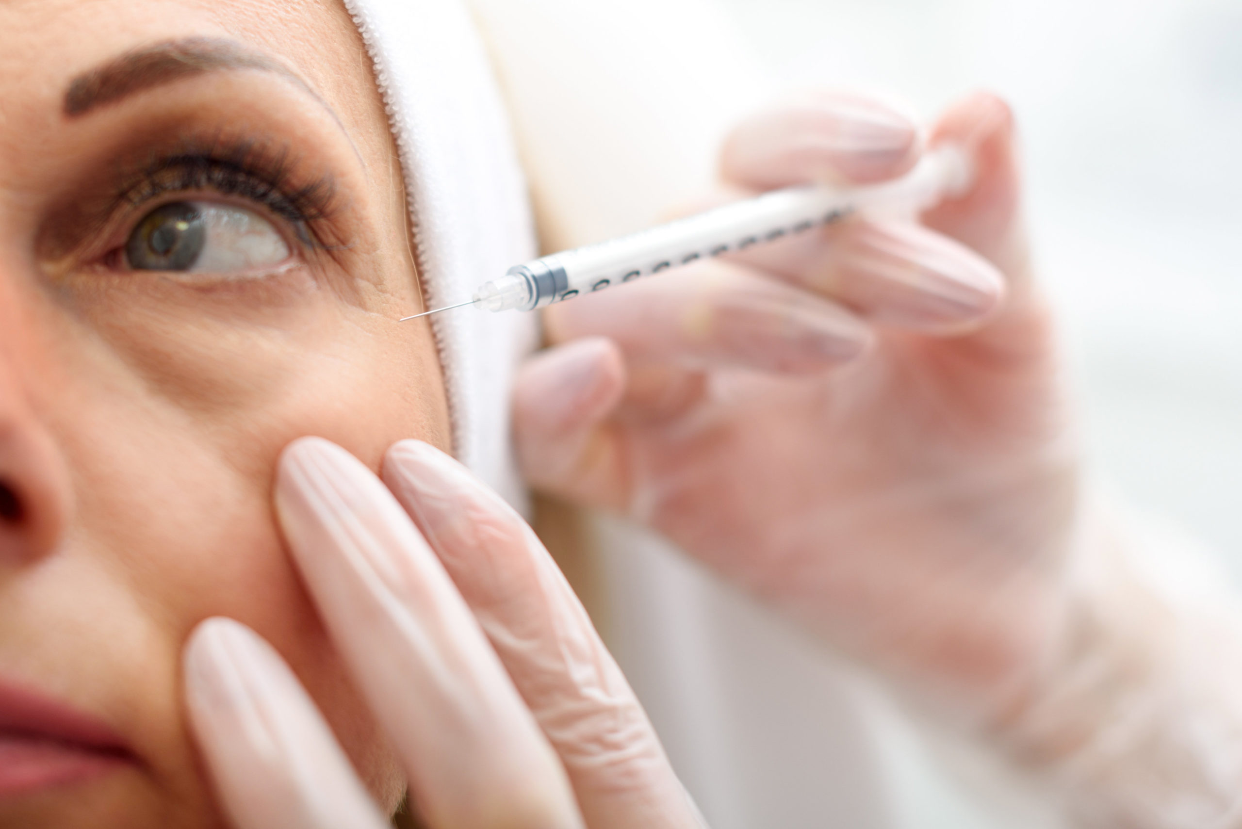 Professional beautician making botox facial injection